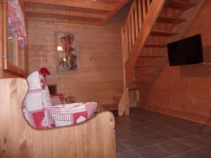 Una sala de estar con escalera y televisor. en Les Noisettes, en La Bresse