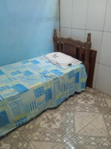 a bed sitting in a room with a tiled floor at Residencial in Belém