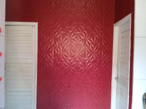 a room with a red wall with a white door at Residencial in Belém