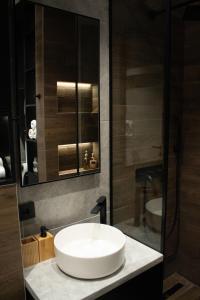 a bathroom with a white sink and a shower at Urban Nest Nis in Niš