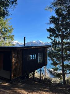 a cabin by the water with mountains in the background at Suite del muelle in San Carlos de Bariloche +16 photos