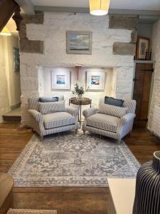 a living room with two chairs and a table at Merchants House in Penryn