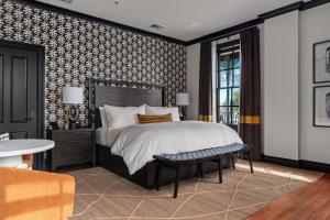 a bedroom with a large bed and a table at Emigrant Boutique Hotel in Fredericksburg