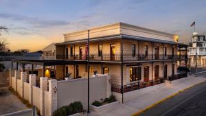 a large brick building with a balcony on a street at Emigrant Boutique Hotel in Fredericksburg