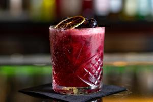 a red drink sitting on a black napkin at Emigrant Boutique Hotel in Fredericksburg +42 photos