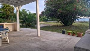 a patio with a table and chairs and a tree at Casetta 28 passi dal mare in Acquappesa