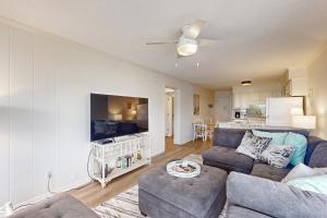 a living room with a couch and a tv at Seaspray 242 in Atlantic Beach