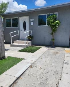 une maison grise avec un arbre en face dans l'établissement Paseo Miami, à Miami
