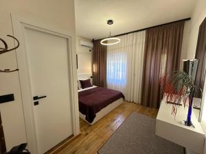 a bedroom with a bed and a door to a room at Manga guesthouse in Gjirokastër