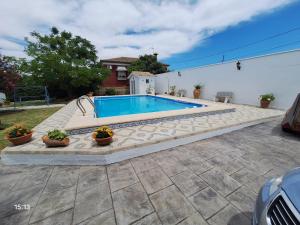 a swimming pool in a yard with potted plants at Chalet casa la adelfa in Chiclana de la Frontera