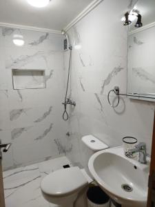 a white bathroom with a toilet and a sink at Le Refuge de Vittel 2 in Ifrane +10 photos