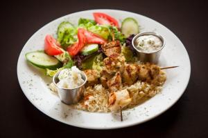 a plate of food with shrimp and rice and a salad at Place 19-67 Restaurant Motel in Plantagenet