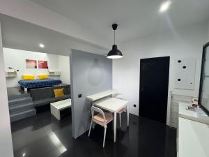 a room with a desk and a bed and a table at Sea Breeze Studios in Porto da Cruz