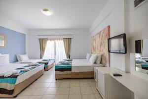 a hotel room with two beds and a tv at MaxSea Beach Hotel in Bodrum City +17 photos