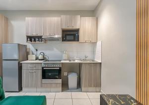 Una cocina con gabinetes de madera y un refrigerador de acero inoxidable. en Charming Studio & Backup Power, en Johannesburgo