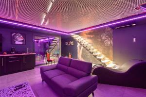 Una sala de estar con un sofá morado y una escalera. en Espace évasions Loft love LOVE ROOM, en Toulouse