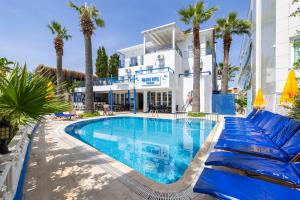 a large swimming pool with palm trees in front of a building at MaxSea Beach Hotel in Bodrum City