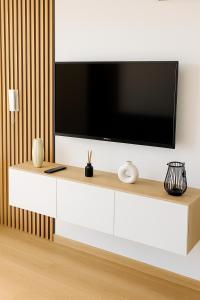 a living room with a television on a white cabinet at RIVER LuX in Veliko Gradište