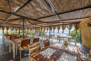 a restaurant with tables and chairs and a view of the ocean at MaxSea Beach Hotel in Bodrum City