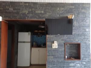 a kitchen with a refrigerator and a brick wall at La mejor vista del Rivero - Entre Dos Mares - Punat del Diablo in Punta Del Diablo +15 photos