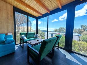 a living room with chairs and a table and windows at Sea view Anika by Vellaris, Luxury Mobile Home in Mali Lošinj