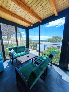 a living room with green furniture and a large window at Sea view Anika by Vellaris, Luxury Mobile Home in Mali Lošinj