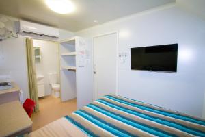 a hotel room with a bed and a television at AAOK Jandowae Accommodation Park in Jandowae