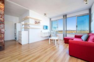 a living room with a red couch and large windows at Encanto da Ria in Faro