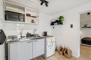 Una cocina blanca con fregadero y estufa. en Gartenwohnung - NEU!In Remscheid - bei Köln, en Remscheid 10 fotos más