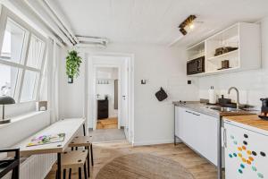 una cocina con armarios blancos y una mesa y un Sidx Sidx Sidx Sidx Sidx. en Gartenwohnung - NEU!In Remscheid - bei Köln, en Remscheid