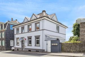 una casa blanca con techo de estaño en Gartenwohnung - NEU!In Remscheid - bei Köln, en Remscheid
