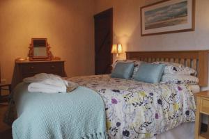 a bedroom with a bed with towels on it at Ystumgwern Luxury Barn Conversions in Dyffryn