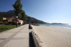 a empty beach with a building and the ocean at Casa Santiago in Ézaro