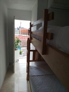 dwa łóżka piętrowe w pokoju z oknem w obiekcie hostal amanecer costero w mieście Santa Marta