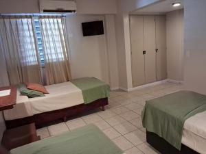 a bedroom with two beds and a tv in it at Esmeralda Palace Hotel in Buenos Aires