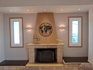 a fireplace in a living room with two windows at Roe Sea View in Kyparissia +45 photos