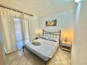 a bedroom with a bed with two lamps and a window at Appartamento Rosè in San Teodoro
