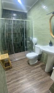 a bathroom with a shower and a toilet and a sink at Peniche Hostel in Peniche