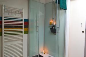 a bathroom with a glass shower with candles in it at Chambre familiale Odile et les cycleux in Docelles +11 photos