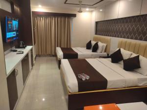 a hotel room with two beds and a television at HoTEL NARMADA GRAND in Vijayawāda +35 photos