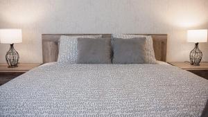 um quarto com uma cama com almofadas e 2 candeeiros em Apartament Piano em Racibórz