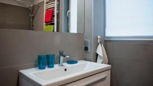a bathroom sink with two blue glasses on it at Apartament Piano in Racibórz
