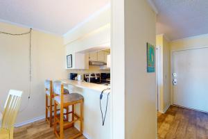 a kitchen with a counter and chairs in a room at A Place At The Beach 281 in Atlantic Beach