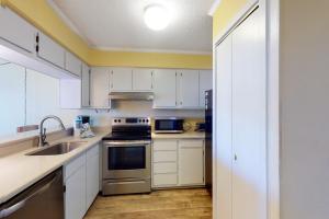 a kitchen with white cabinets and stainless steel appliances at A Place At The Beach 281 in Atlantic Beach