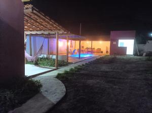 a house with a swimming pool at night at Espaço Girassol Chalé Itaitu in Jacobina