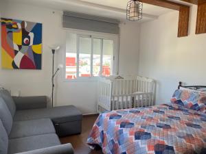 a bedroom with a bed and a couch and a crib at Equipped studio in Tetouan in Tétouan