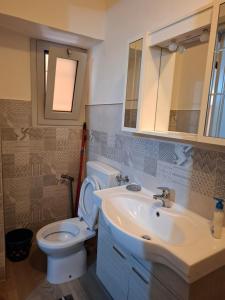 a bathroom with a white toilet and a sink at Appartamento Batticuore in Torre Pellice