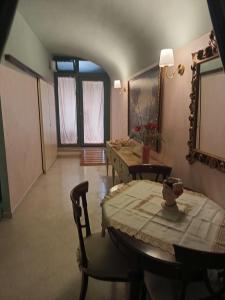 ein Wohnzimmer mit einem Tisch, Stühlen und einem Spiegel in der Unterkunft Casa Arco di Cupido in Barletta
