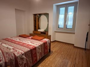 a bedroom with a bed and a large mirror at Appartamento Batticuore in Torre Pellice