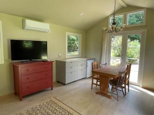 a dining room with a table and a television at Gästhus nära västersjön in Munka-Ljungby
